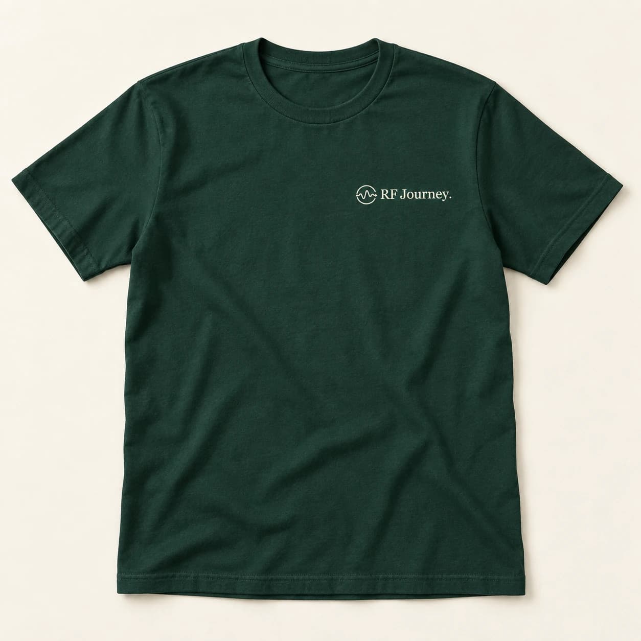 Concept mockup of a forest green T-shirt with a small, light RF Journey logo on the chest.